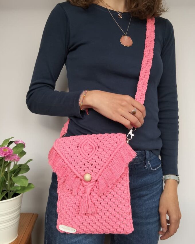 Bolso rosa de macramé con solapa en pico y cierre de borla