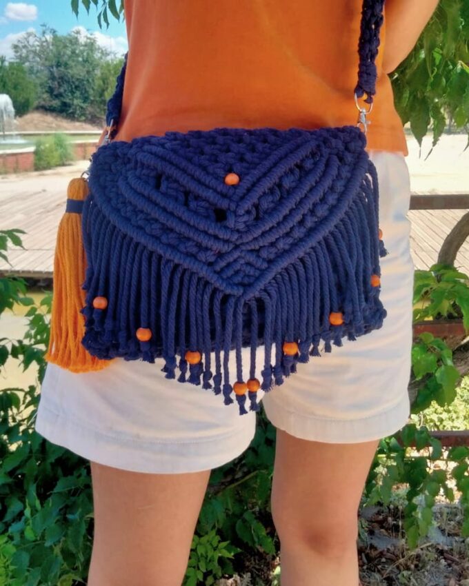Bolso de macramé azul marino con solapa y bolitas naranjas