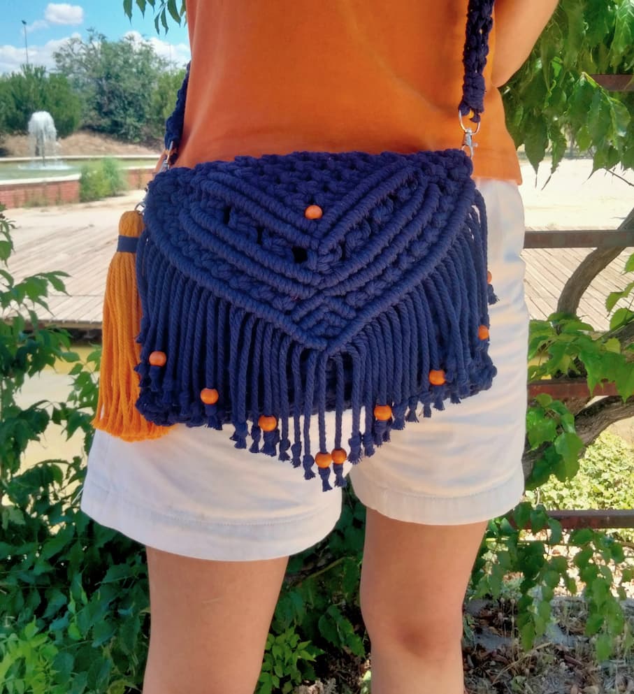 Bolso de macramé azul marino con solapa y bolitas naranjas
