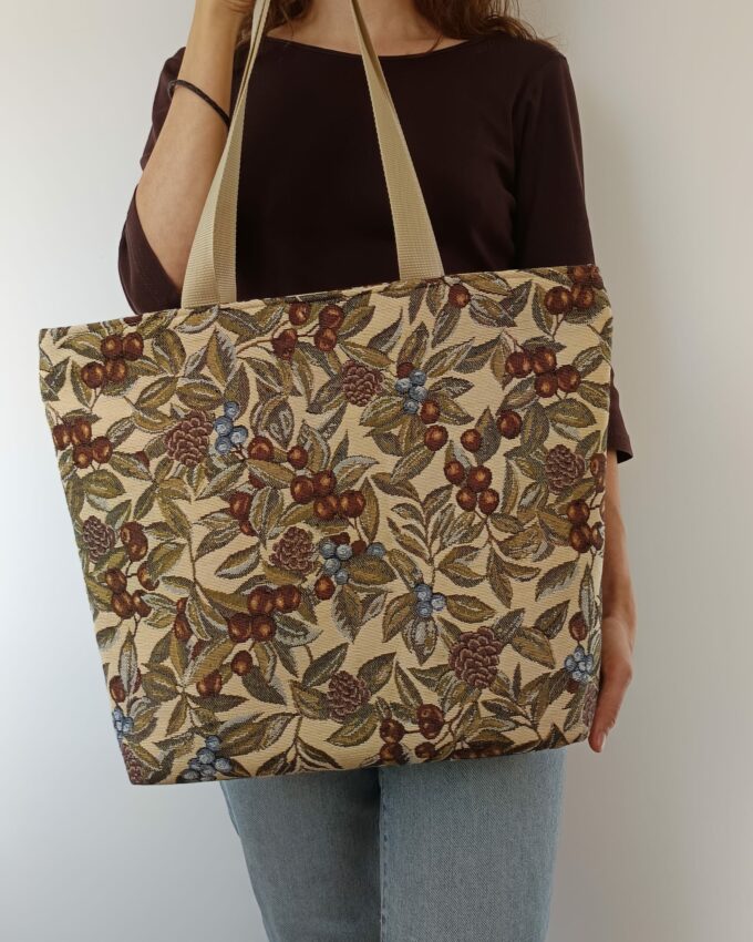 Tote de lona resistente con estampado de frutos silvestres en beige, verde y marrón.