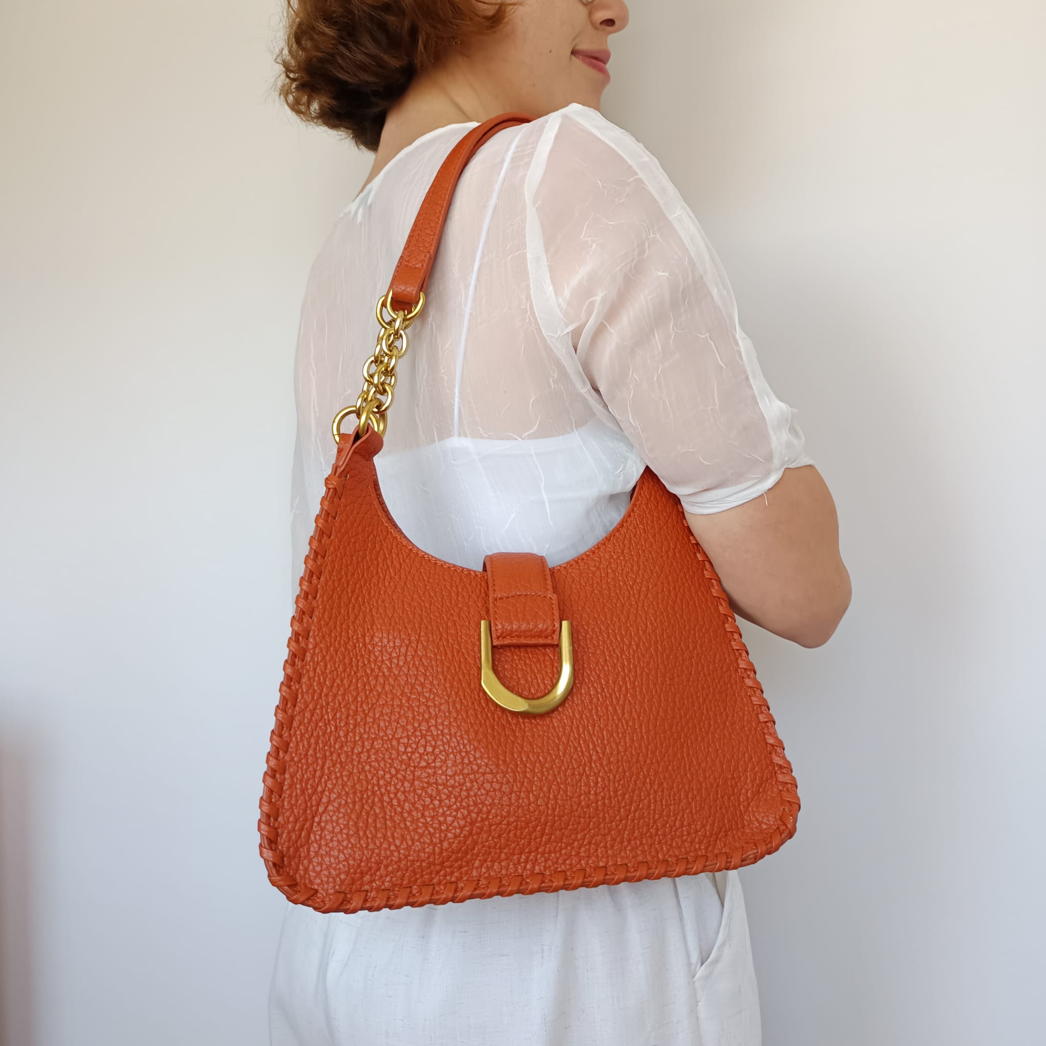 Bolso polipiel naranja ocre con asa de cadena dorada