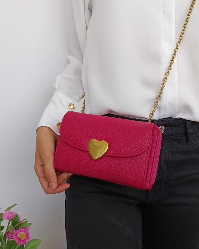 Bolso de polipiel fucsia con broche de corazón y cadena dorada