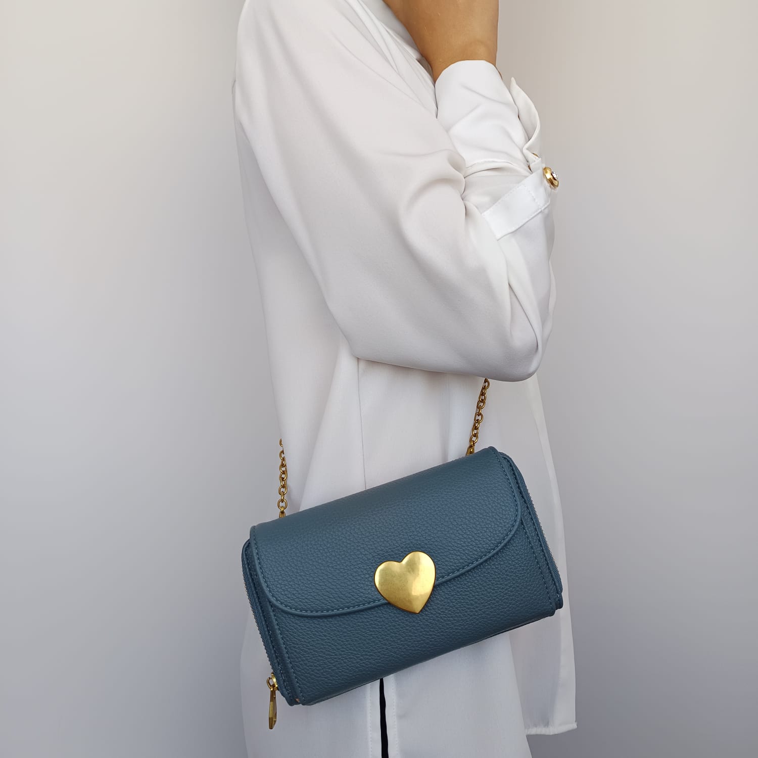Bolso azul de polipiel con broche en la solapa y asa dorada